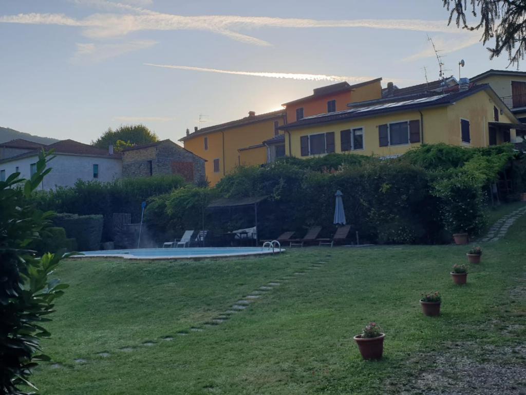 un patio con una casa y una piscina en B&B Tenuta Campo Magliano, en Bigliolo
