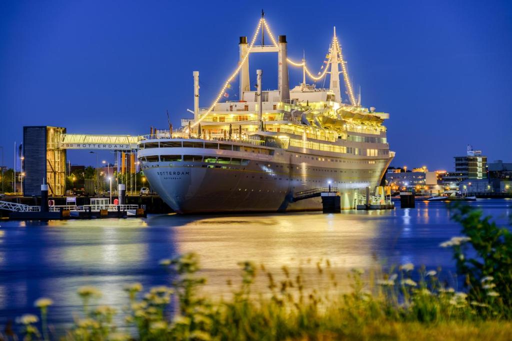 een cruiseschip aangemeerd in een haven 's nachts bij ss Rotterdam Hotel en Restaurants in Rotterdam