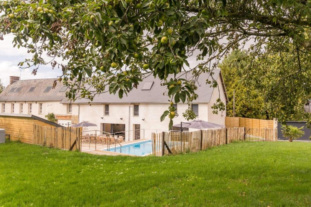 ein Haus mit einem Zaun und einem Pool in der Unterkunft Au jardin de Capucine in Bricqueville-sur-Mer