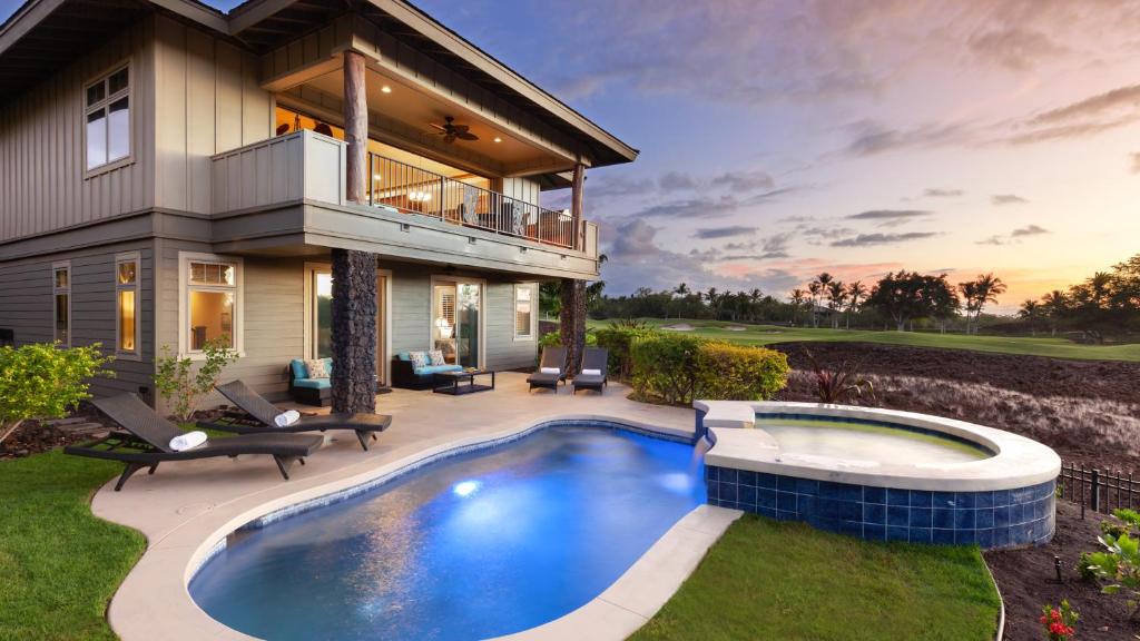 a house with a swimming pool in front of a house at HEAVENLY DAYS Stunning Views from KaMilo 3BR Home with Heated Pool in Waikoloa