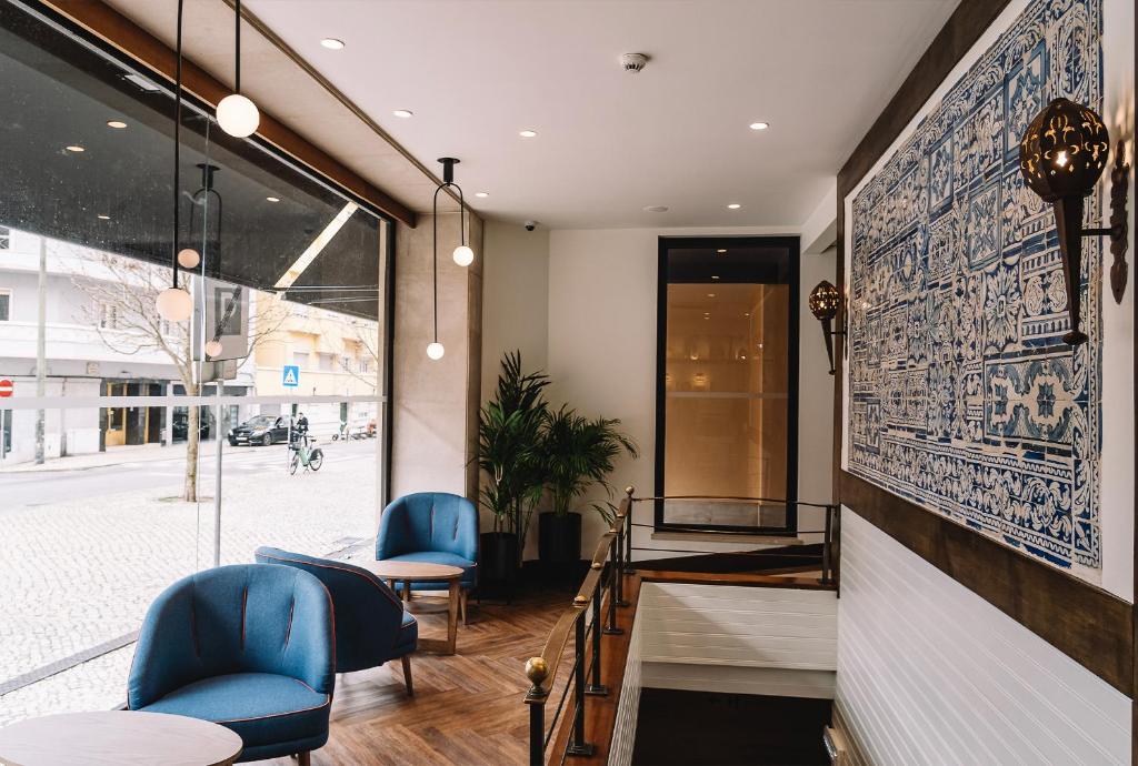 un restaurant avec des chaises bleues et un mur orné d'une fresque murale. dans l'établissement Real Residência - Apartamentos Turísticos, à Lisbonne