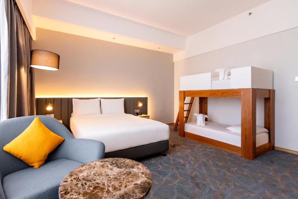 セパンにあるHoliday Inn Sepang - Airportのベッドと椅子付きのホテルルーム