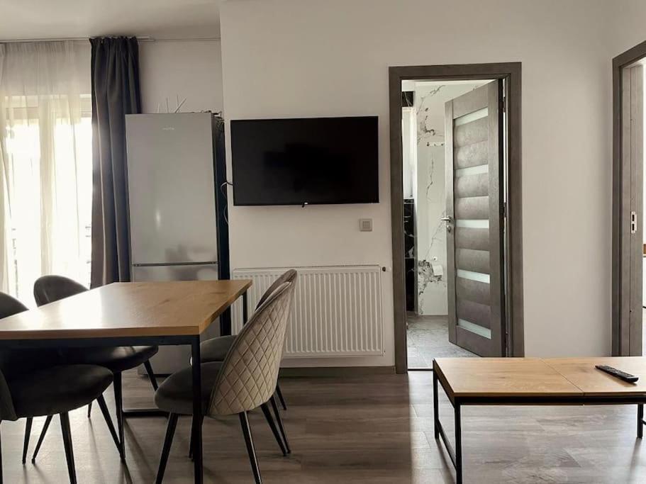 - un salon avec une table, des chaises et une télévision dans l'établissement Serenity Haven Retreat, à Floreşti