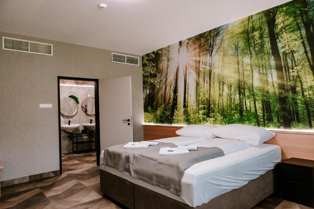 1 dormitorio con 1 cama y una gran pintura en la pared en Park Hotel Sóstó, en Nyíregyháza
