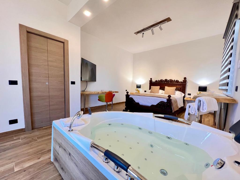 een groot bad in een kamer met een bed bij Carrubba's luxury home in San Giovanni la Punta