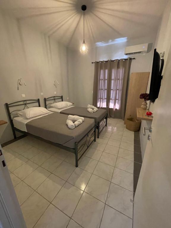 a bedroom with two beds and a tv in it at Sidari Centre Apartments in Sidari
