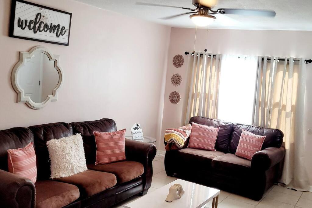 a living room with two leather couches and a mirror at Cozy By The Sea - Hutchinson Island - A in Fort Pierce