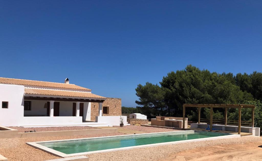 a villa with a swimming pool and a house at Casa S'Olibassa in La Mola