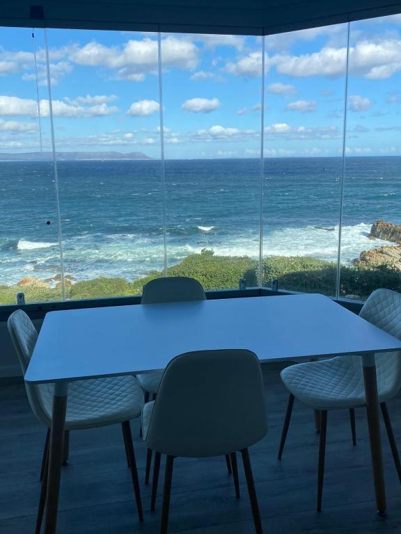 a blue table with chairs and a view of the ocean at Bayview 208 in Hermanus
