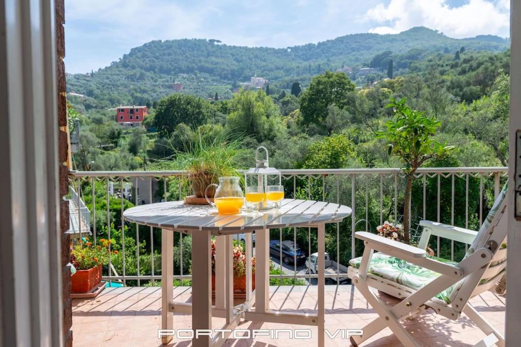 a table with two glasses of orange juice on a balcony at Appartamento Via Madonnetta by PortofinoVip in Santa Margherita Ligure