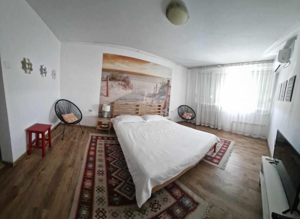una camera da letto con un letto e un dipinto sul muro di Sunny Place Garsoniera -posibilitate self check in a Craiova