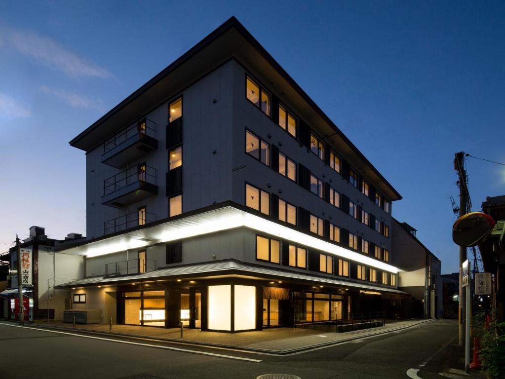 a building on a street with lights on at Hotel Glad One Kyoto Shichijo by M's in Kyoto