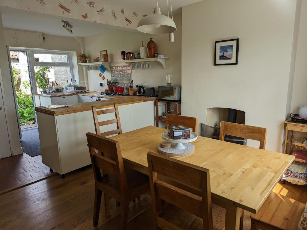 cocina con mesa de madera, mesa y sillas en Cosy family cottage south Somerset, en Long Sutton