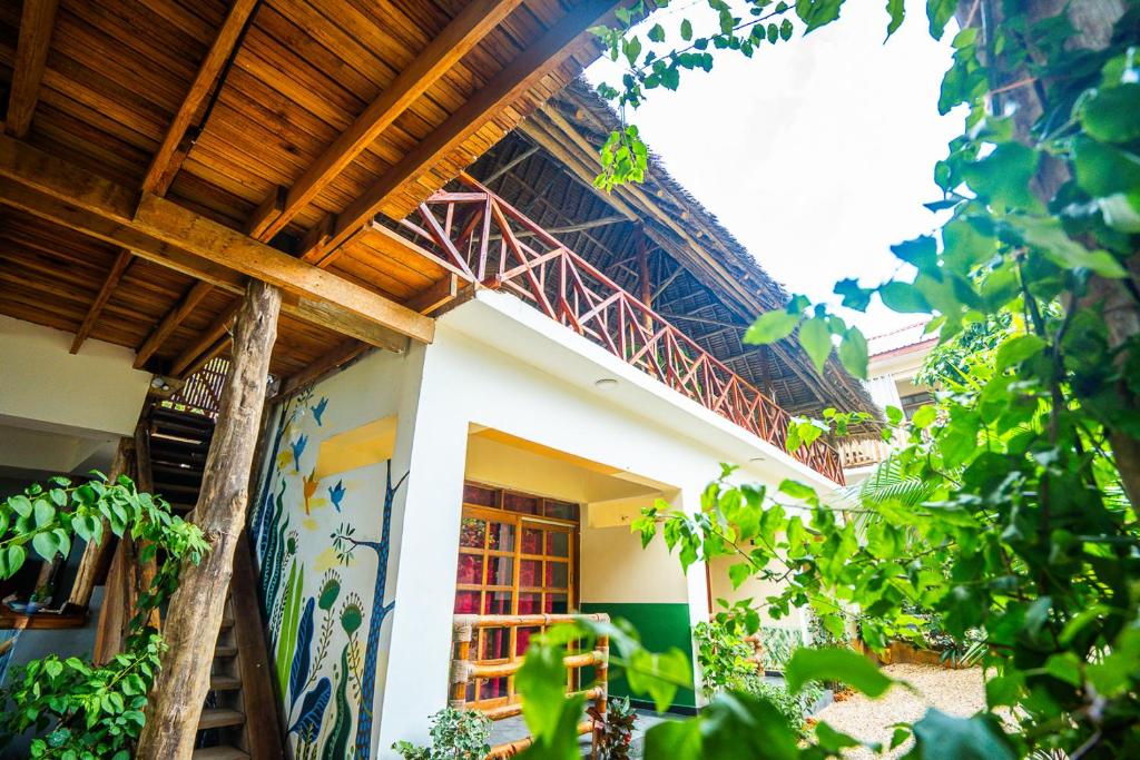 Casa con techo de madera y balcón en La Fontana Restaurant & Bungalows, en Kendwa