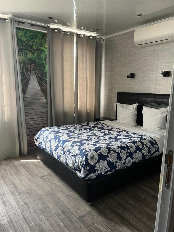 een slaapkamer met een bed met een blauwe en witte deken bij Hôtel des 2 Gares in Auxerre