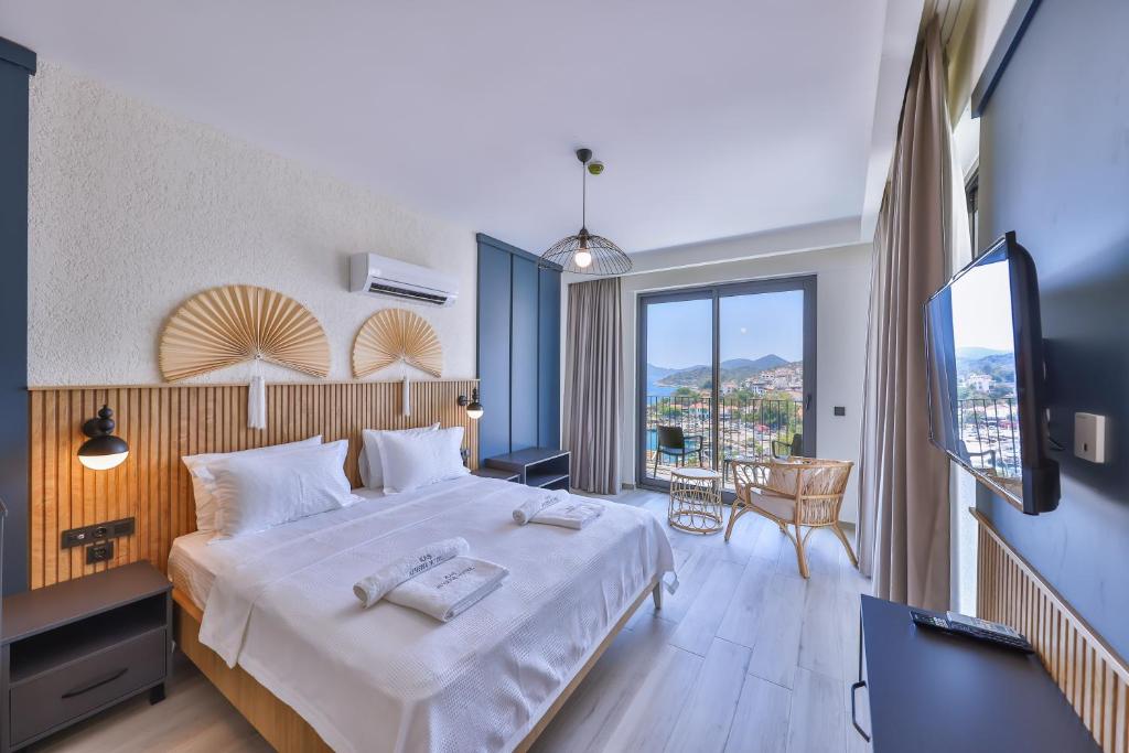 a hotel room with a bed and a large window at Kas Athena Hotel in Kaş