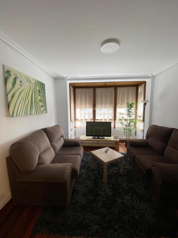 sala de estar con 2 sofás y TV de pantalla plana en Apartamento Gernika, en Guernica y Luno