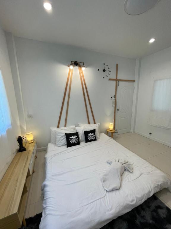 ein Schlafzimmer mit einem großen weißen Bett mit zwei Kissen in der Unterkunft กาลเวลา เกาะสีชัง in Ban Tha Thewawong