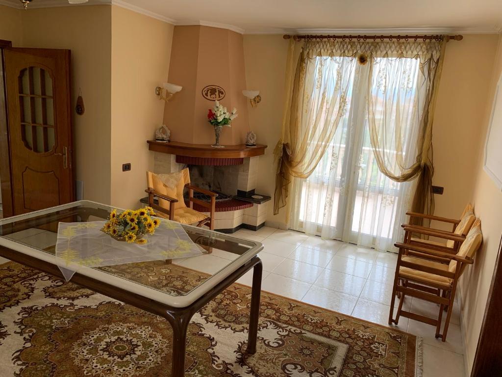 a living room with a glass table and a fireplace at “Tek Riki” in Korçë