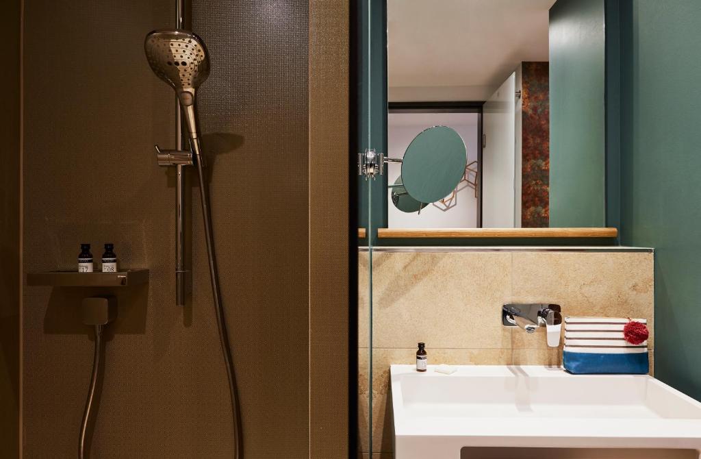 a bathroom with a shower and a sink and a mirror at Hotel Indigo Dresden - Wettiner Platz by IHG in Dresden
