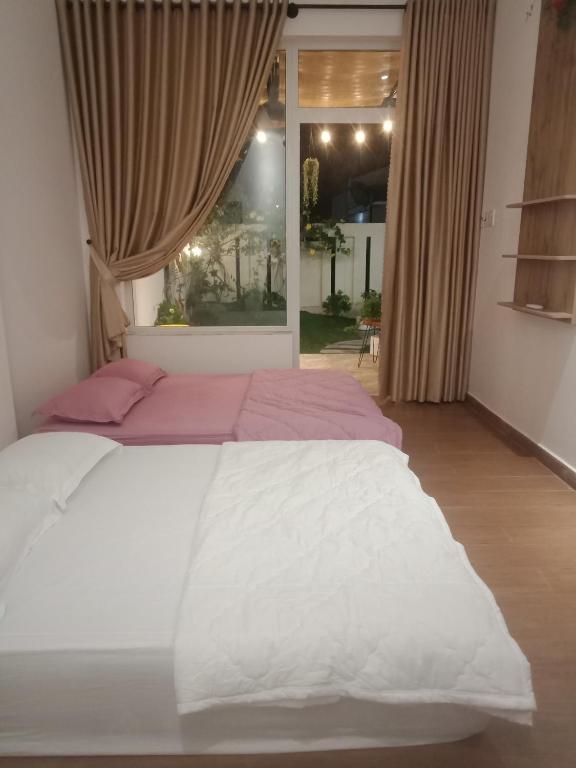 ein großes Bett in einem Schlafzimmer mit Fenster in der Unterkunft TRANG DOAN'S HOMESTAY in Ấp Tân Bình (2)