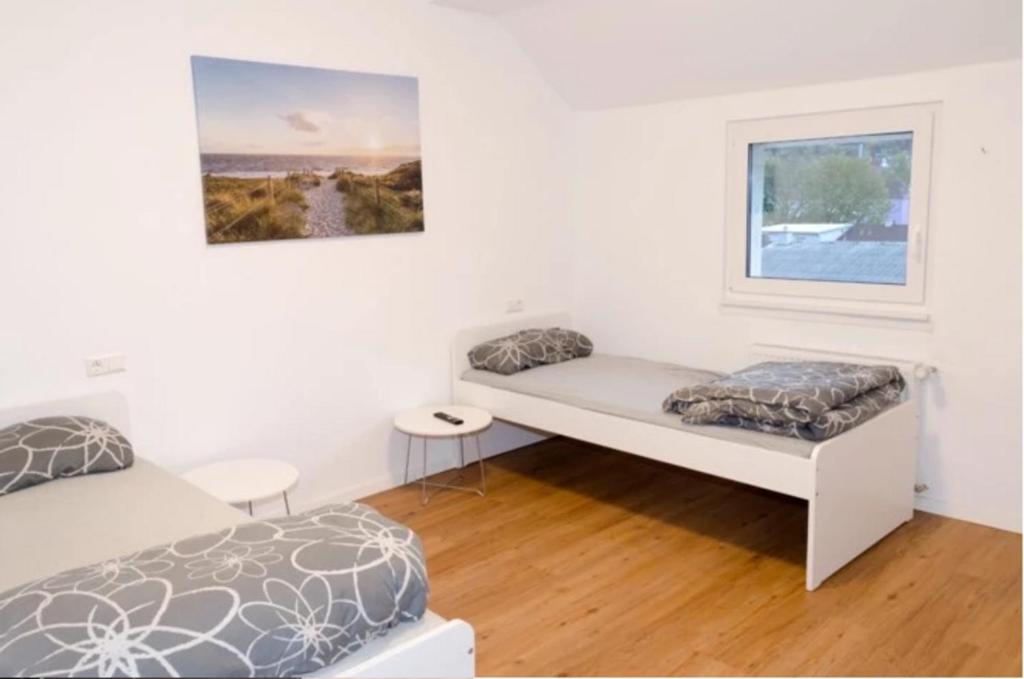 ein weißes Schlafzimmer mit einem Bett und einem Fenster in der Unterkunft Wohnung Bruchsal in Bruchsal