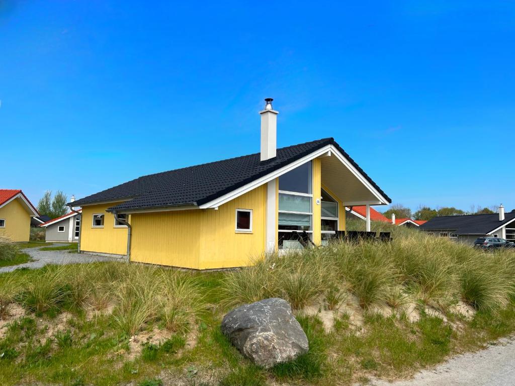a yellow house with a black roof at Resort 2 Sea Lodge C 65 in Großenbrode