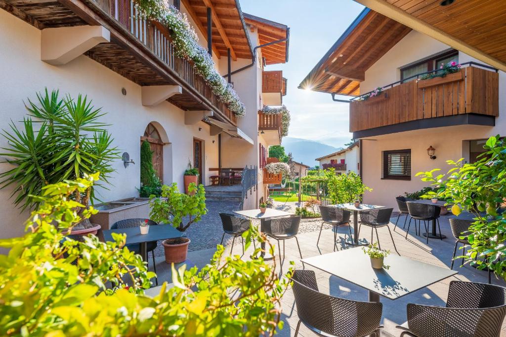 un patio extérieur avec des tables, des chaises et des plantes dans l'établissement Rebenheim, à Termeno