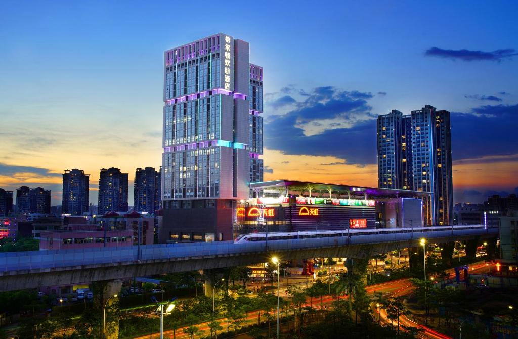 een skyline van de stad met een hoog gebouw en een brug bij Hampton by Hilton Zhuhai Cheng Feng Plaza in Zhuhai