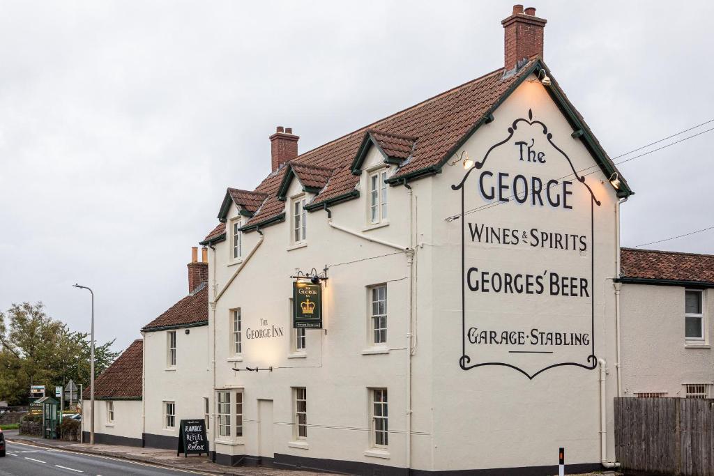 a white building with a sign on the side of it at The George at Backwell in Nailsea