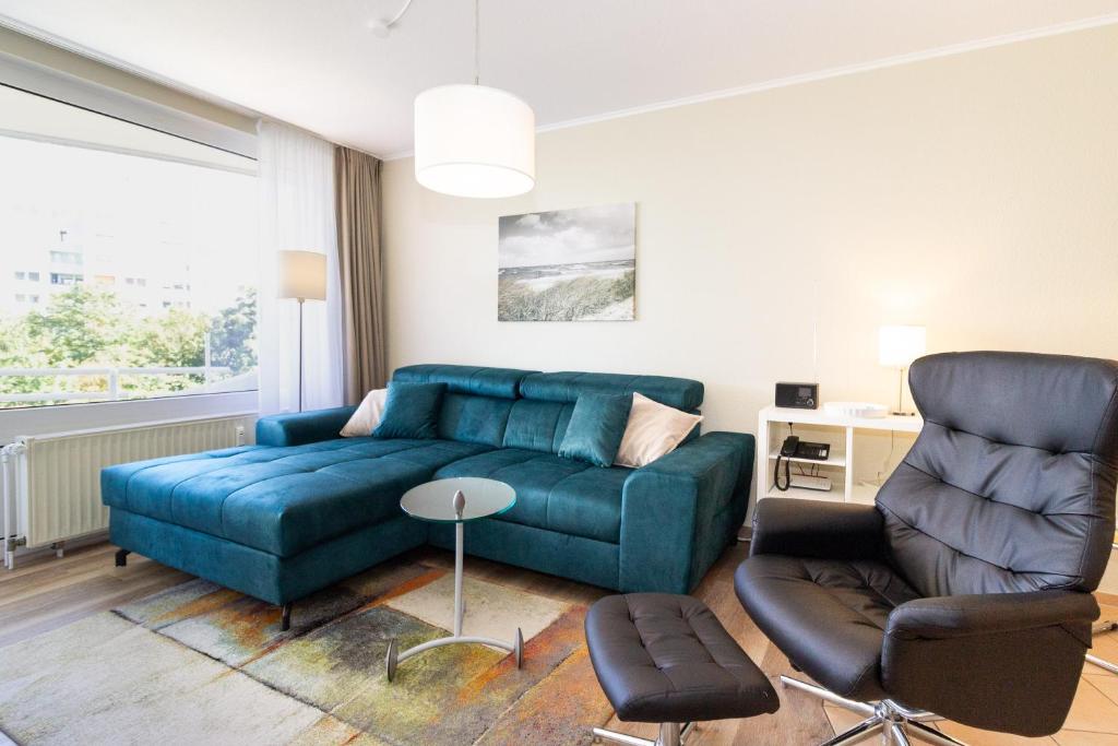 a living room with a blue couch and a chair at Lord Nelson 215 in Döse