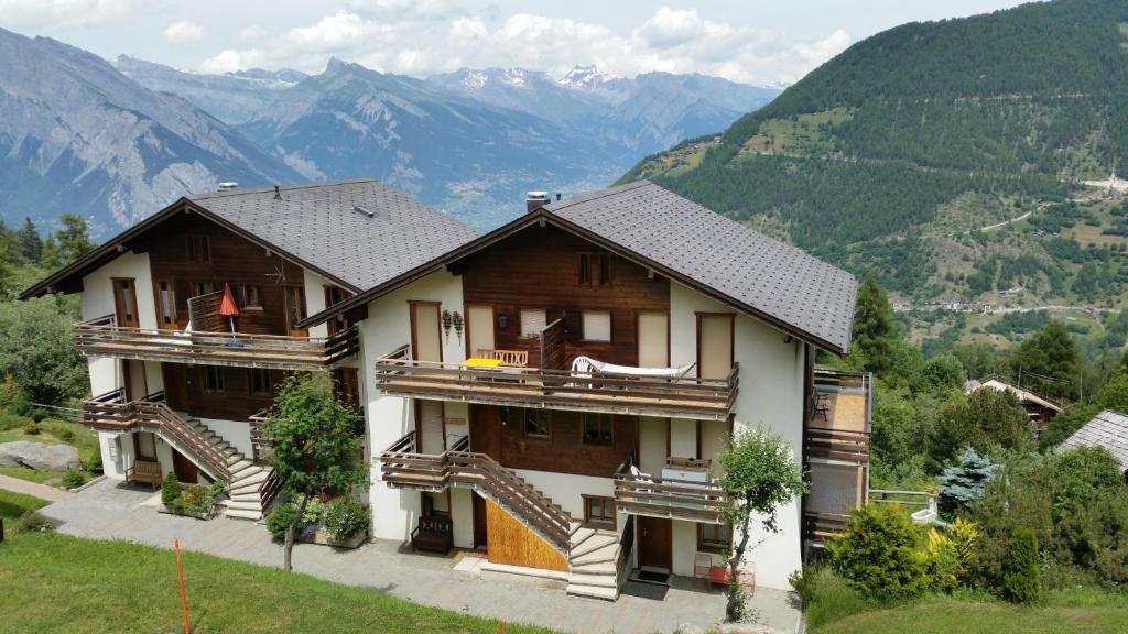 a large house with mountains in the background at Appartement Arolles 704 in La Tzoumaz