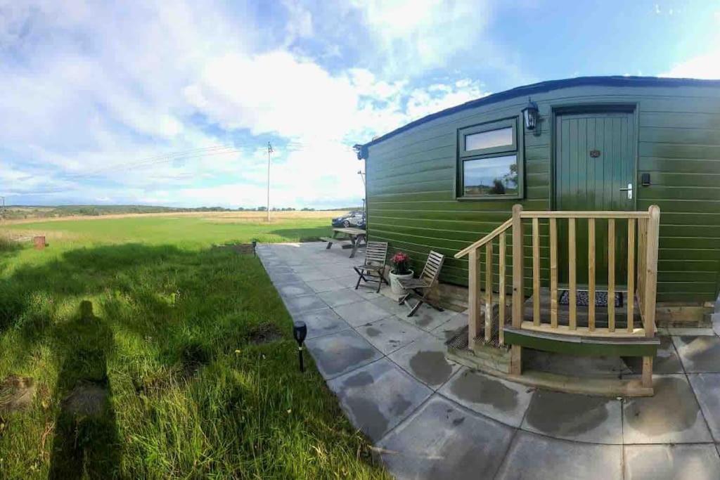 einem grünen Wohnwagen mit einer Veranda und einer Terrasse in der Unterkunft Runaway Northumberland in Morpeth