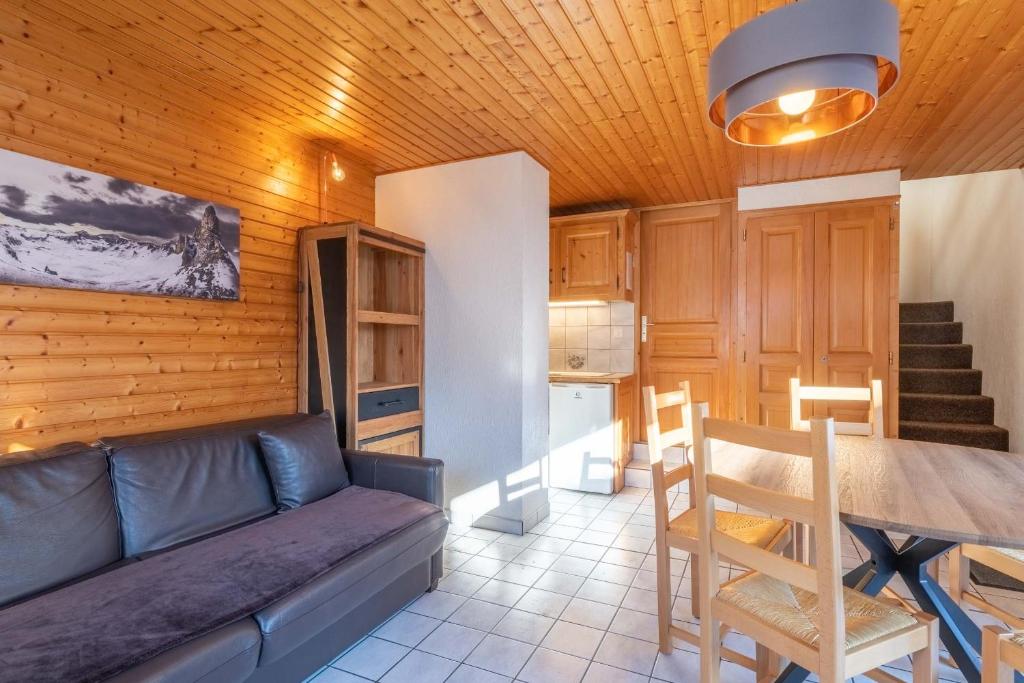 a living room with a couch and a table at Hôtel Les Côtes, Résidence Loisirs et Chalets in Morzine