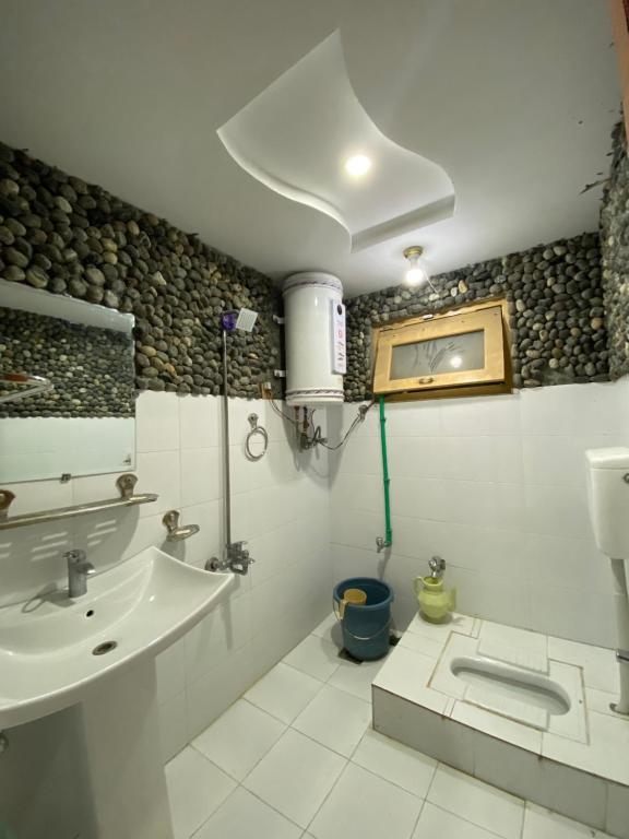 a bathroom with a sink and a toilet in it at Royal Guest House in Skardu