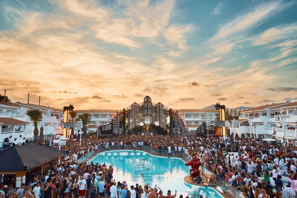 Une foule nombreuse de gens se tenant autour d'une piscine lors d'un carnaval dans l'établissement Ushuaia Ibiza Beach Hotel - Adults Only-Entrance to Ushuaia Club included, à Playa d'en Bossa