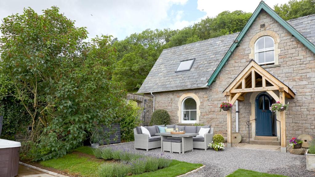 a stone house with a patio with couches at Wallhope Retreat in Chepstow