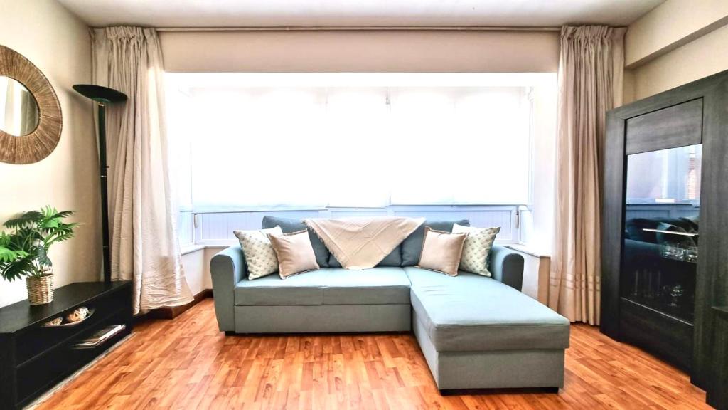 sala de estar con sofá y ventana grande en Sofia´s Canto del Mar en Candás