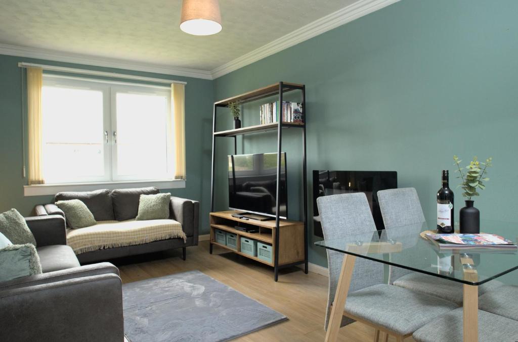 uma sala de estar com um sofá e uma mesa em Modern 2-Bed Haven, FREE PARKING em Edinburgo
