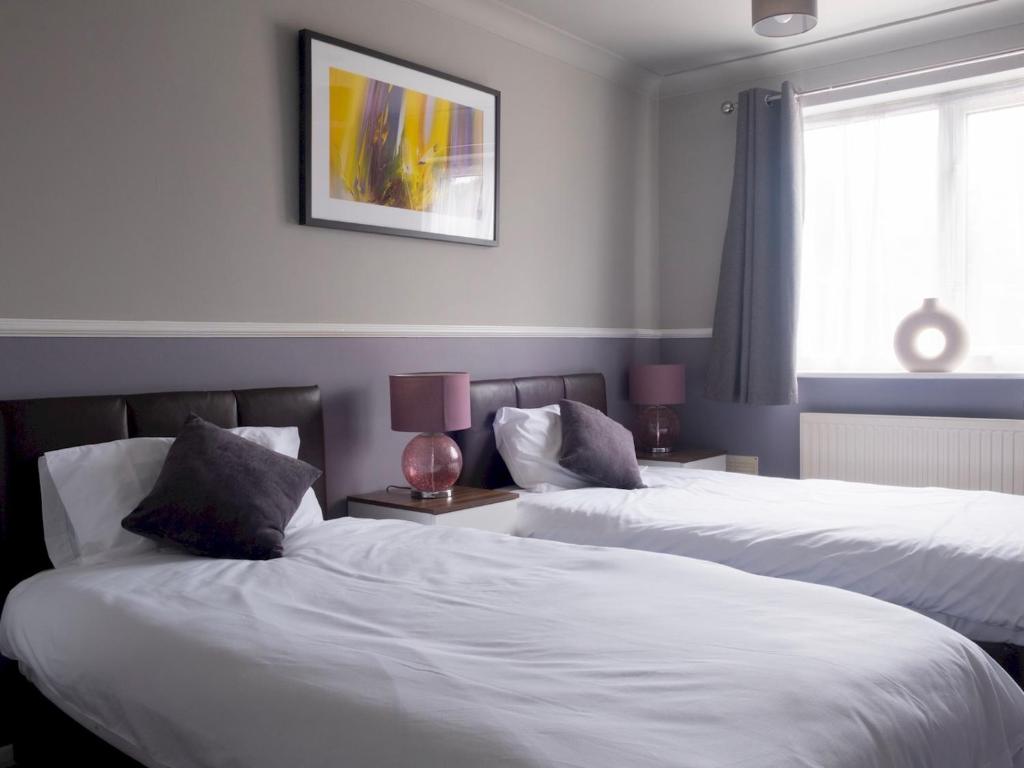 two beds in a hotel room with white sheets at Pass the Keys Flat close to amenities in Scunthorpe