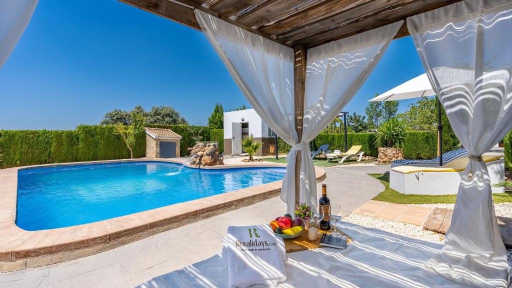 eine Villa mit einem Swimmingpool und einem Tisch mit Obst darauf in der Unterkunft La Pedriza de Loja by Ruralidays in Loja