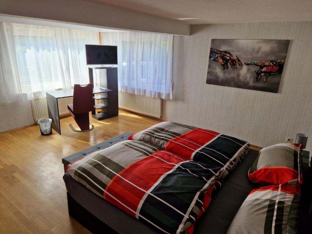 a bedroom with a bed and a desk at Föller´s Gästehaus in Neu-Anspach