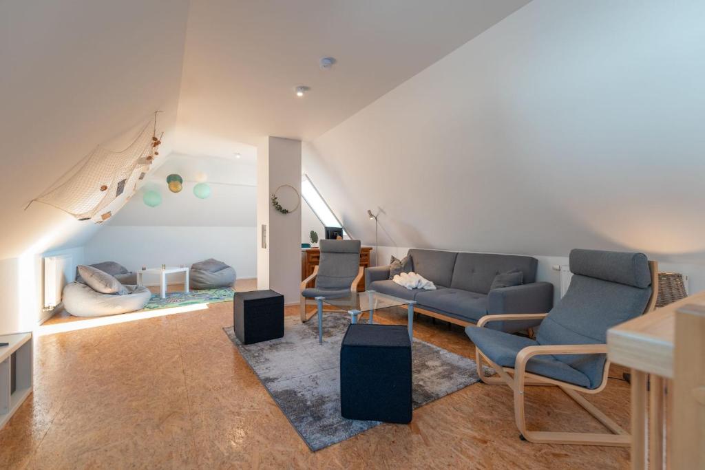 una sala de estar con sofás y sillas y una escalera en Ferienwohnung Schwanensee, en Kolpinsee