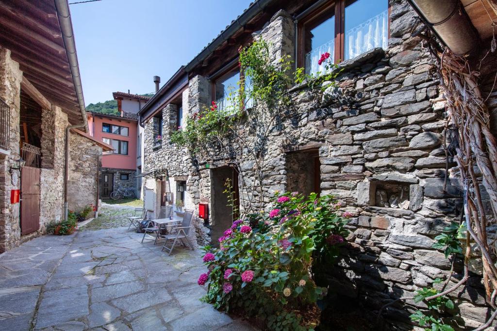 a stone building with flowers on the side of it at Rustico Stock - Happy Rentals in Lugano