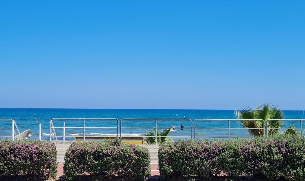 a view of the ocean from a beach with bushes at The Ciao Stelio Deluxe Boutique Hotel - Adults Only in Larnaka