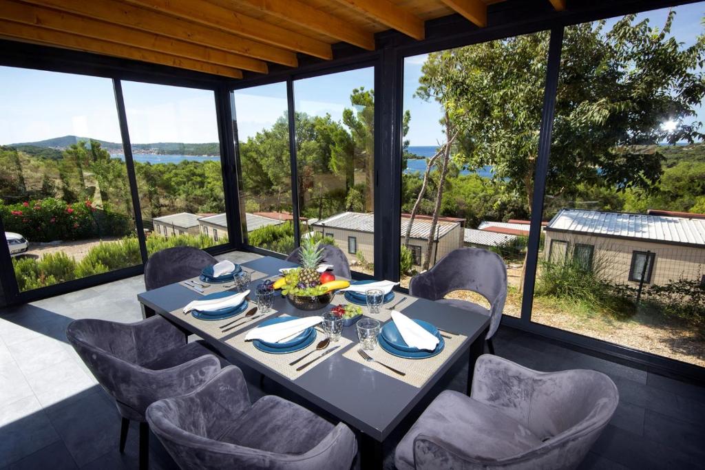 a dining room with a table and chairs at KastHouse Luxury mobile home Anika in Mali Lošinj