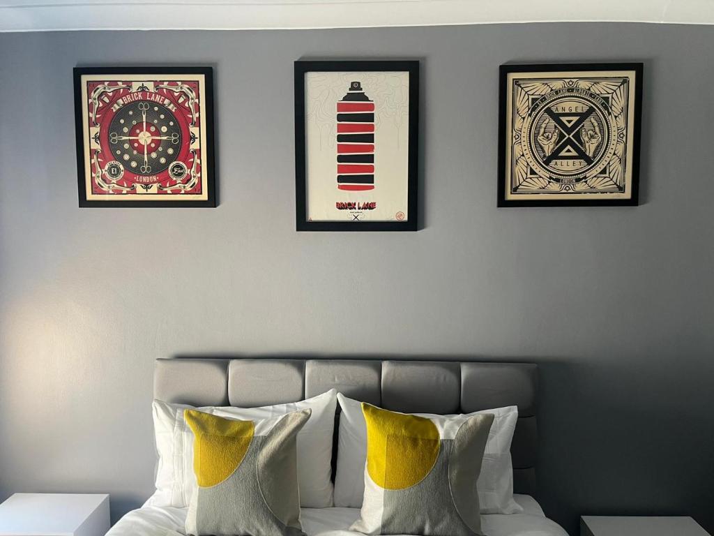 a bedroom with three framed pictures above a bed at The E17 Suite in London