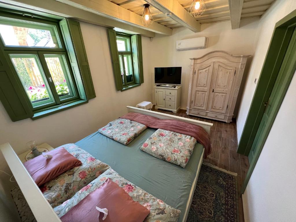 een slaapkamer met twee bedden en een televisie bij Pannonhalma Várlak Vendégház in Pannonhalma