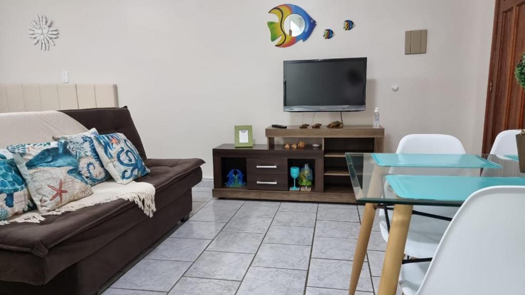sala de estar con sofá y TV en Apartamento Praia Grande, en Praia Grande
