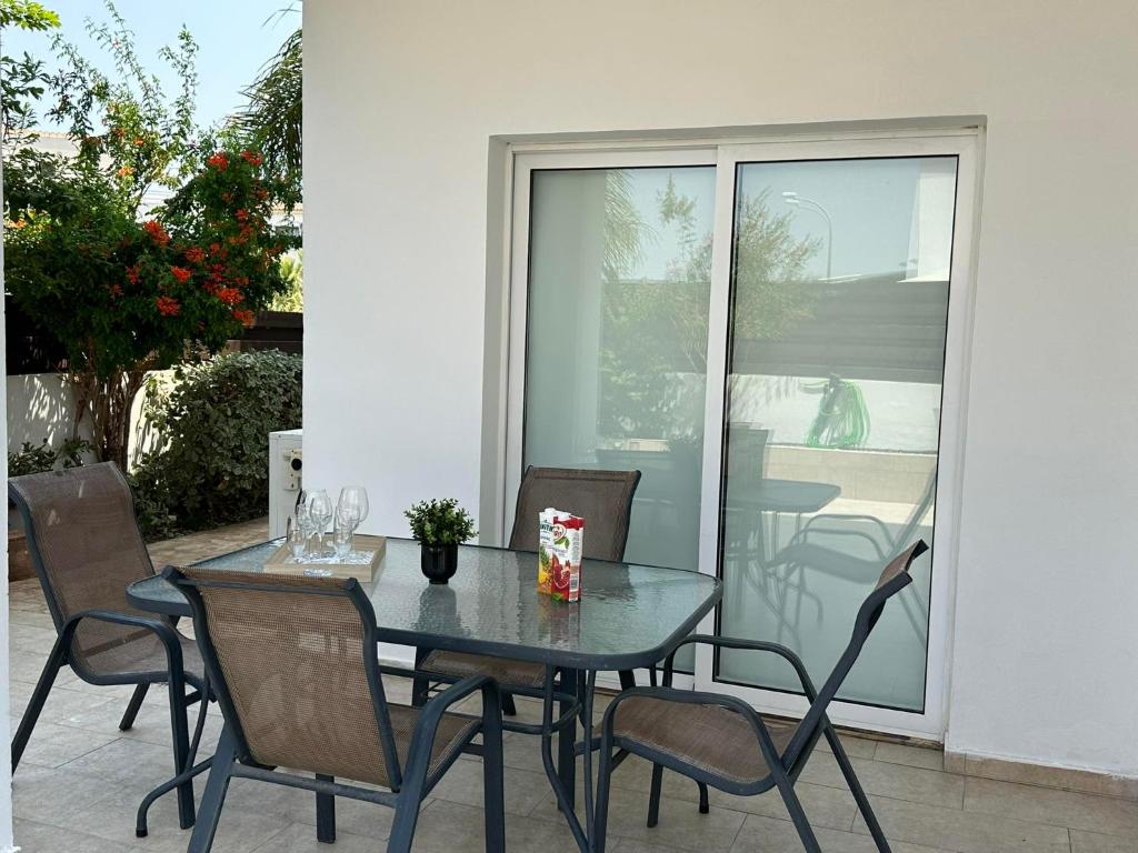 a dining table and chairs on a patio at Sidra's Apartment in Paralimni